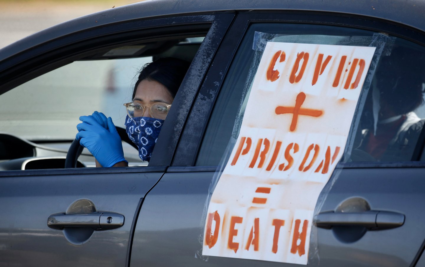 A women in a car with a poster reading 