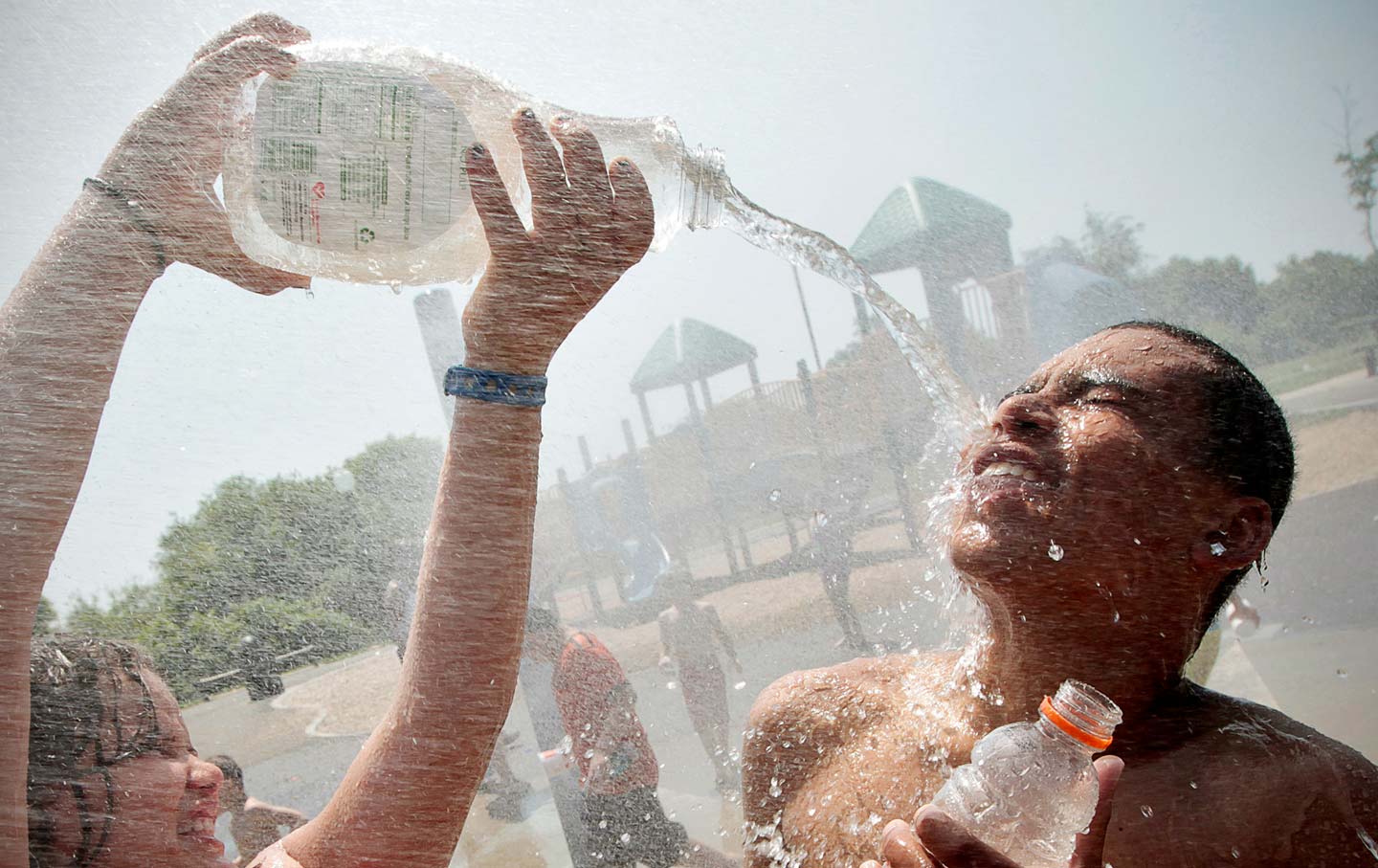 Paige Avila cools off her brother Eric Avila in Massachusetts in a 2012 heat wave.