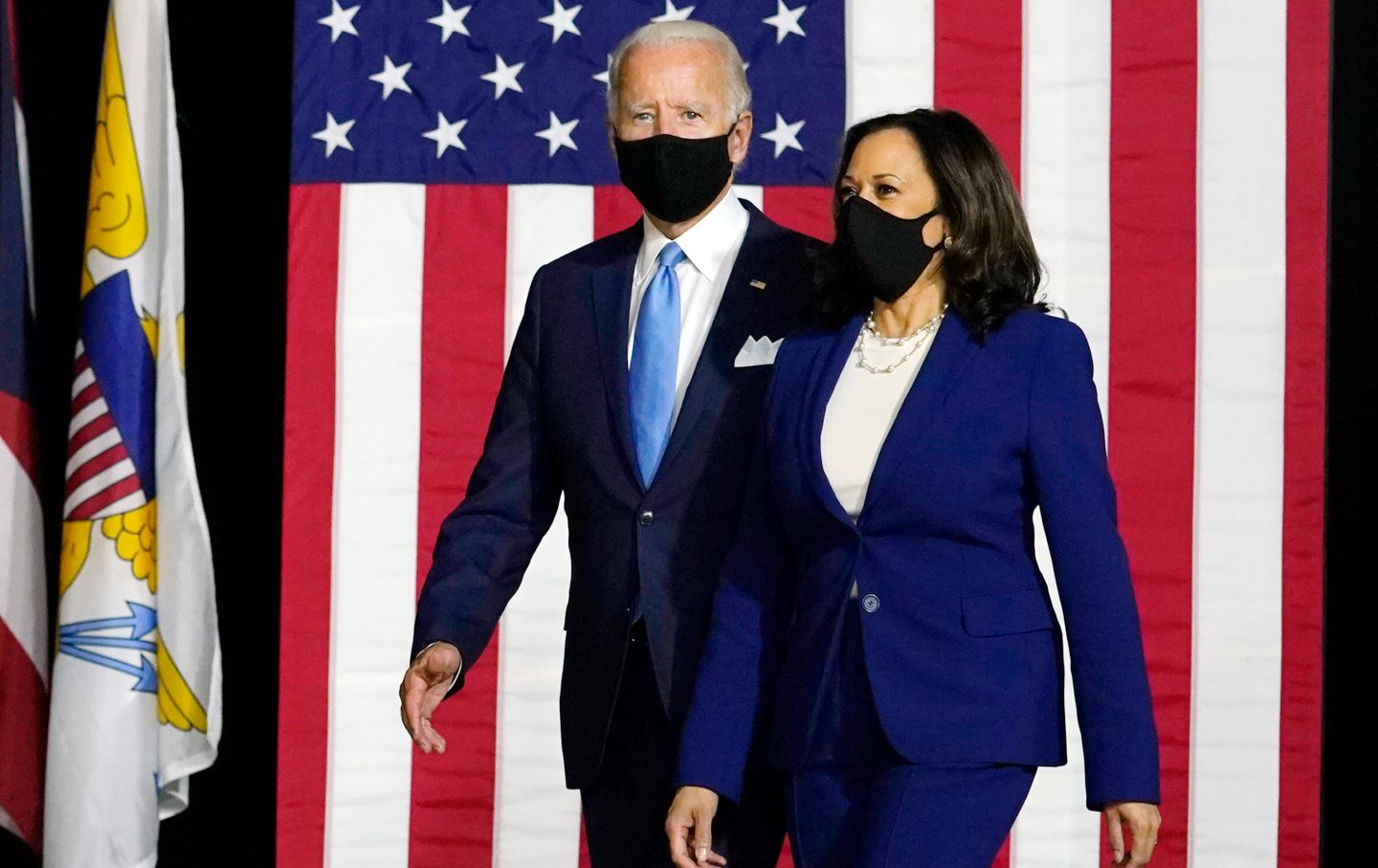 Biden and Kamala walking in front of an American flag