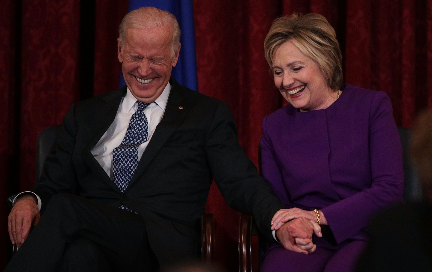 Former US secretary of state Hillary Clinton shares a moment with Vice President Joe Biden during a portrait unveiling ceremony for Senate minority leader Senator Harry Reid on December 8, 2016.