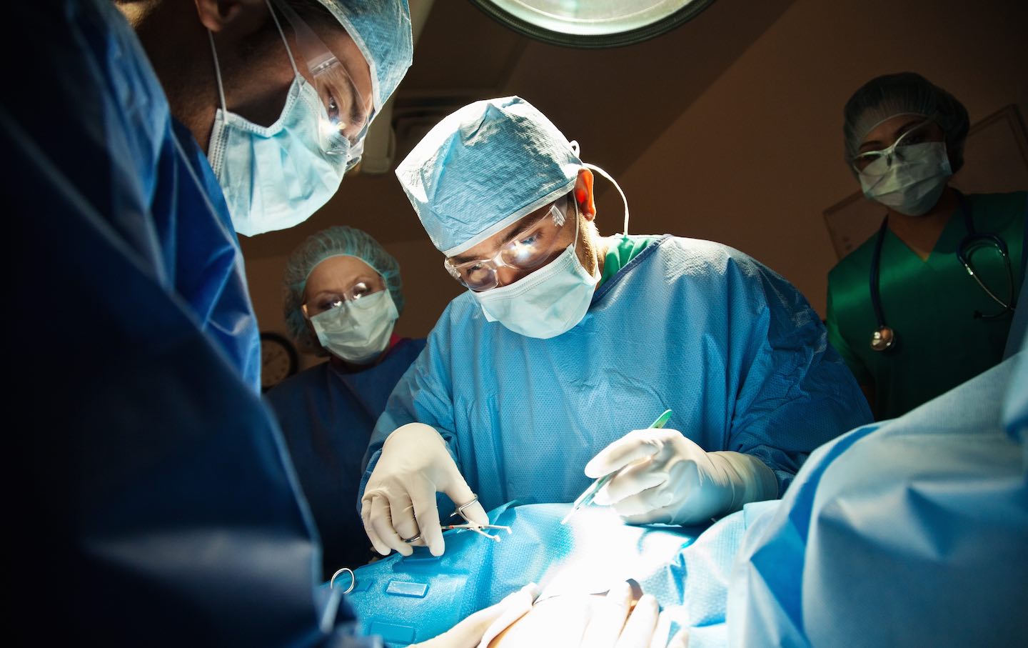 A surgeon performs a C-Section in the operating room