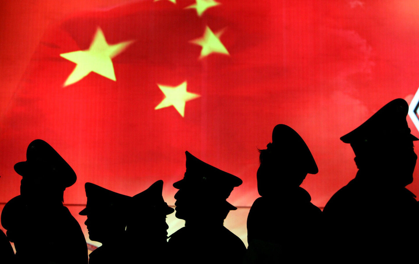 Security guards walk past the Chinese national flag at the Military Museum of Chinese People's Revolution on March 1, 2008, in Beijing, China.