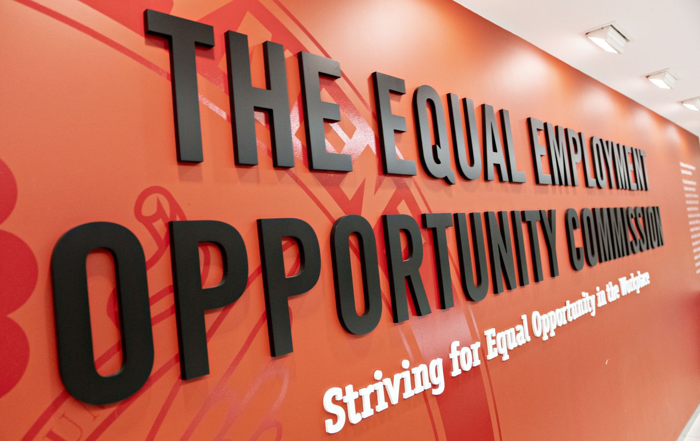 The wall at the entrance of the Equal Employment Opportunity Commission, with the name of the agency in large type and below. 
