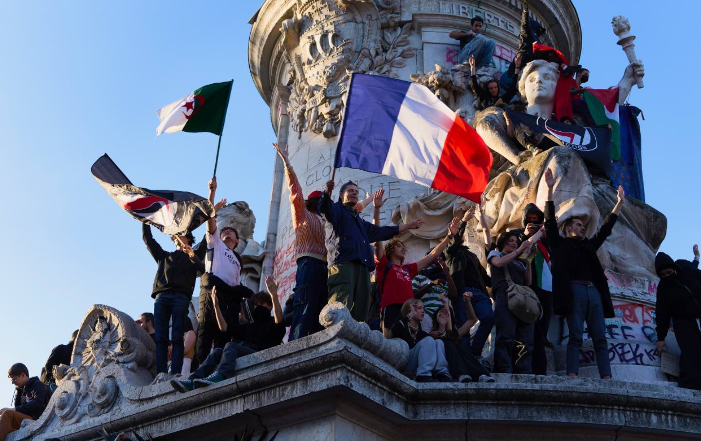 People are seen celebrating on the statue of Marianne on the Place de la République to celebrate after the Nouveau Front populaire, an alliance of left-wing parties including La France Insoumise came in first on July 7, 2024, in Paris, France.