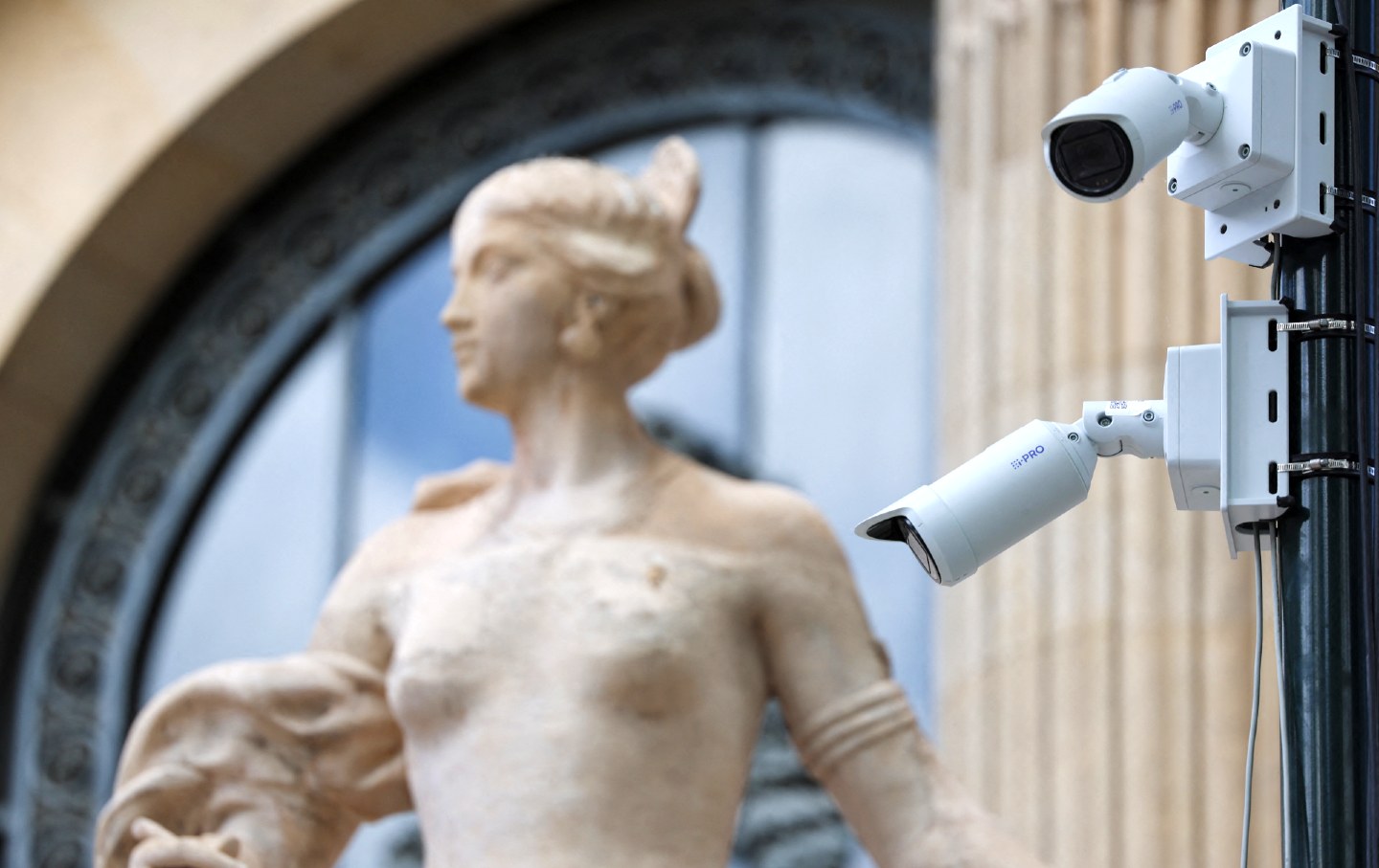 A CCTV surveillance camera watches the Olympic crowds with a statue of the Grand Palais Olympic site in the background in Paris on July 22, 2024.