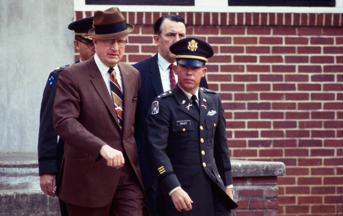 US Army Lt. William Calley leaves military court with civilian attorney George Latimer and military attorney Maj. Kenneth Raby at the conclusion of several days of pre-trial hearings. Calley is on trial for his role in the My Lai massacre during the Vietnam War.