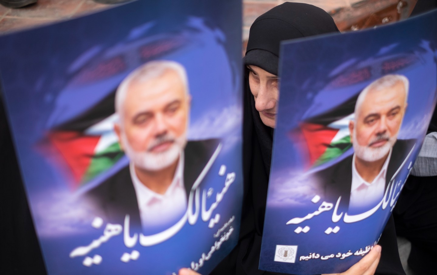 Iranian mourners hold portraits of Hamas leader Ismail Haniyeh during a funeral ceremony for him and his bodyguard Abu Shaaban in Tehran, Iran, on August 1, 2024.