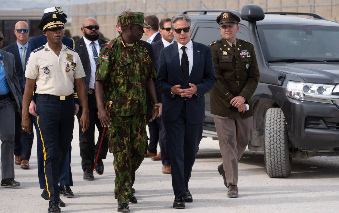 Anthony Blinken walking with a man in a Haitian military uniform