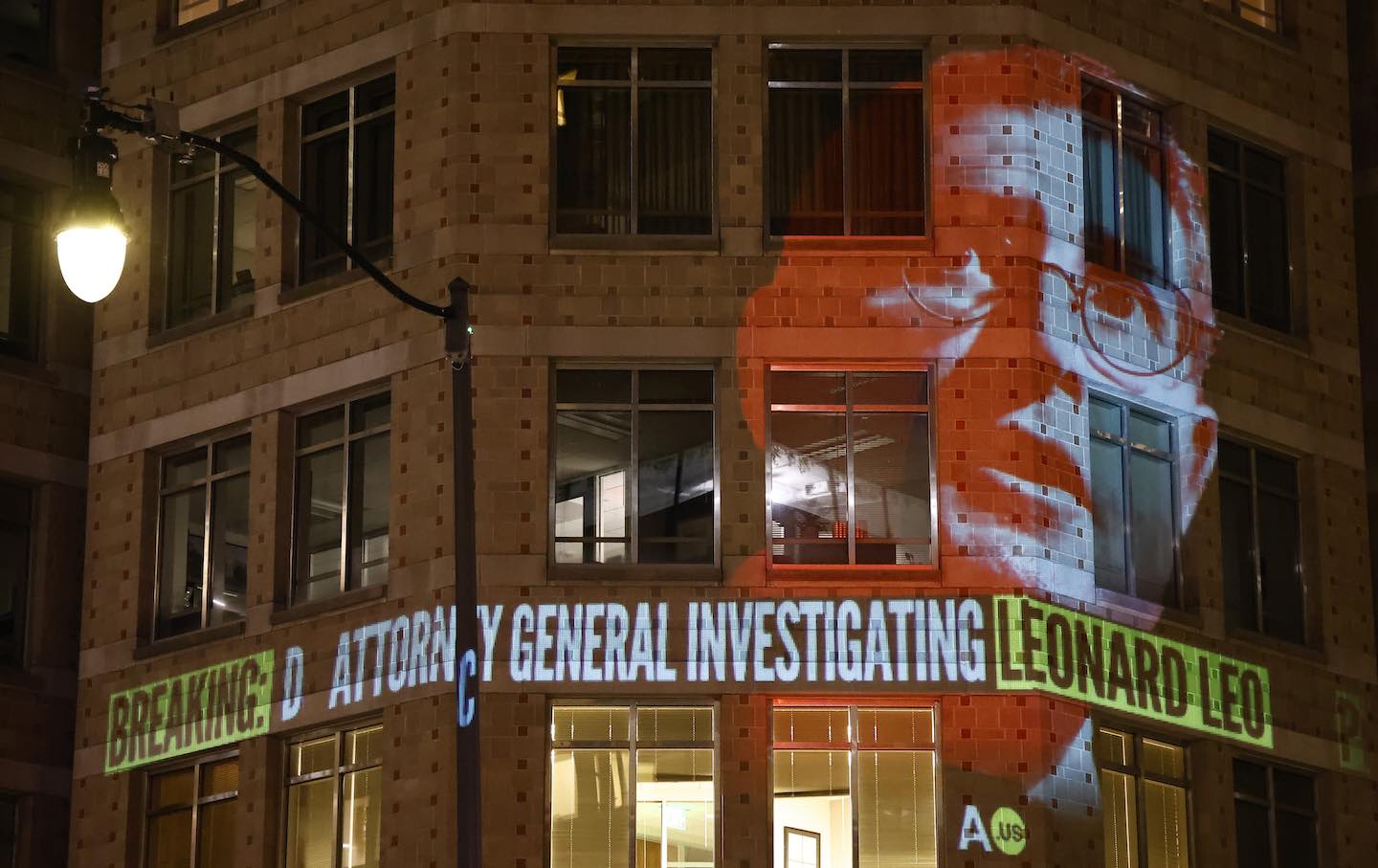 Government watchdog Accountable.US projects a graphic onto the Federalist Society building to highlight news of DC Attorney General Brian Schwalb’s investigation into conservative kingpin Leonard Leo’s nonprofit network in August 2023.