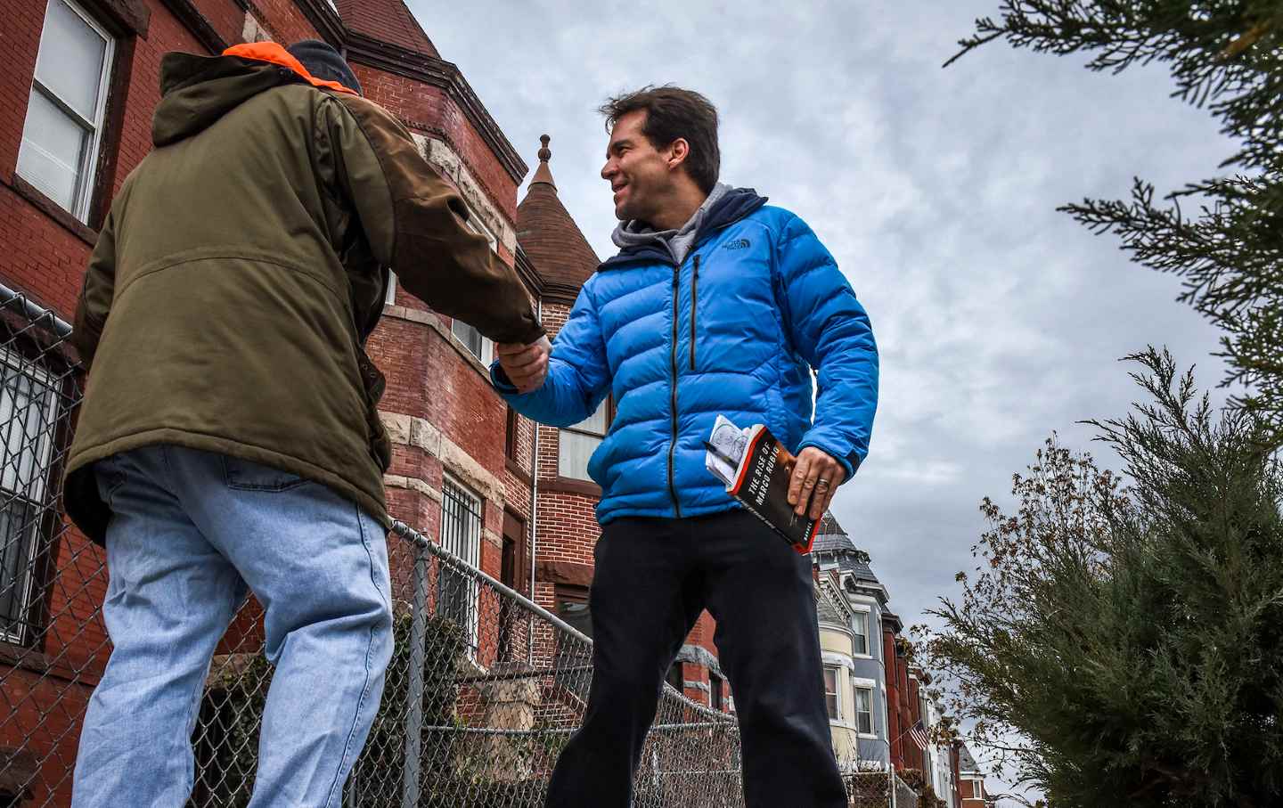 Jack Burkman, the lobbyist who has put a sizable donation to solve the murder of Seth Rich, shakes hands with a resident after a short discussion of the case on January 10, 2017, in Washington, DC.