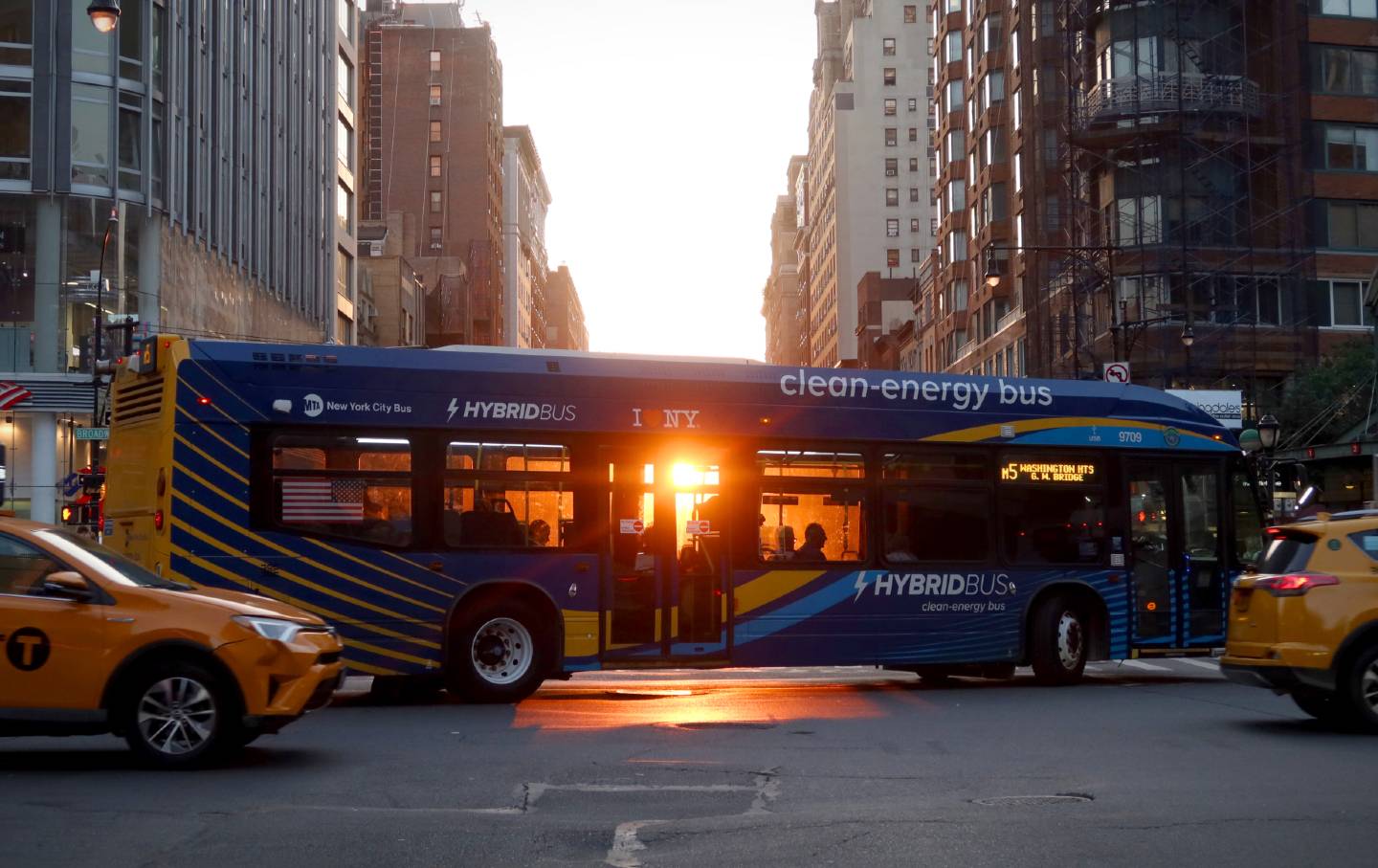 People sit on an MTA bus as the sun sets along 72nd Street on June 12, 2024, in New York City.