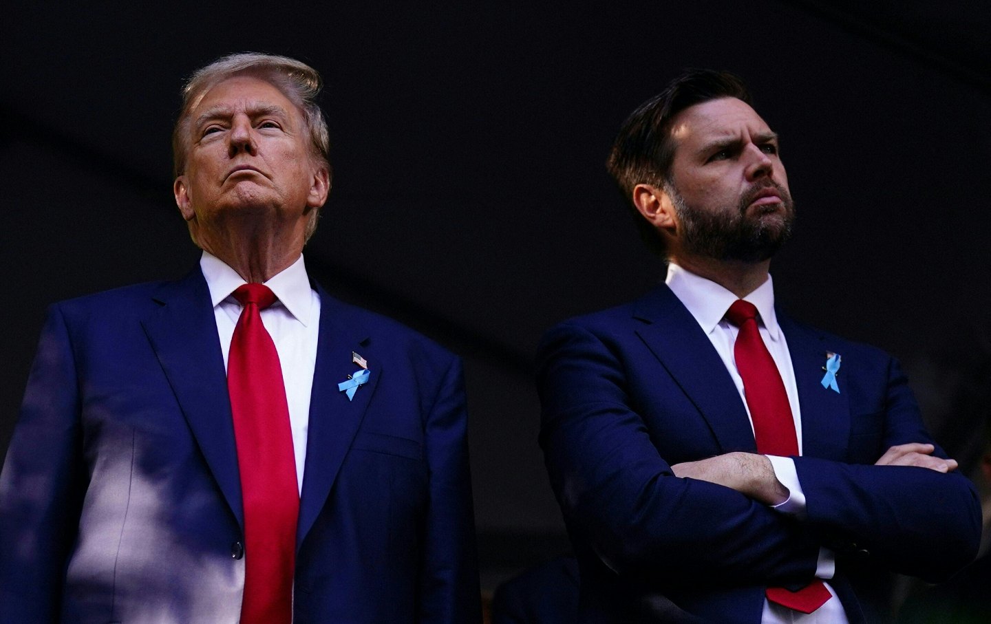 Former President Donald Trump next to Ohio Sen. JD Vance, both frowning, both in blue suit jackets and red ties.