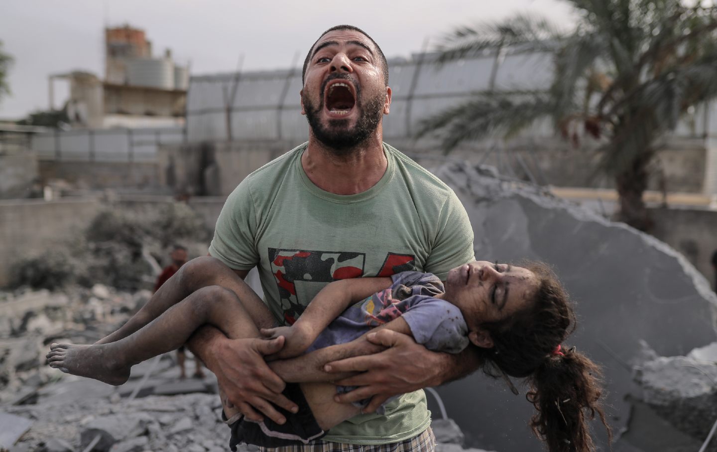 A Palestinian man holds the dead body of his cousin.