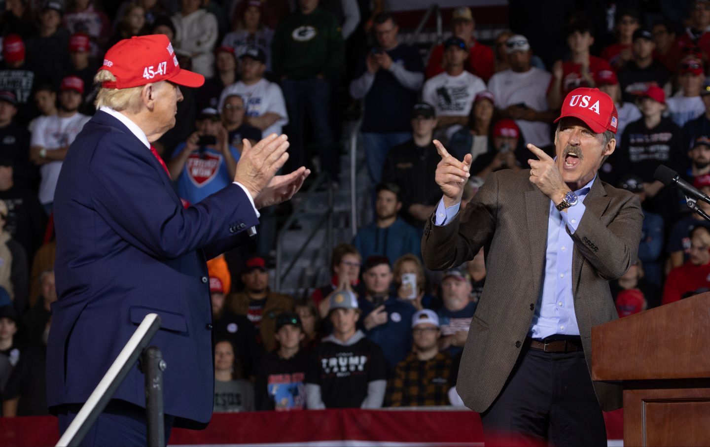 Donald Trump listens as GOP candidate for the US Senate for Wisconsin Eric Hovde speaks during a rally at Dodge County Airport on October 6, 2024, in Juneau, Wisconsin.