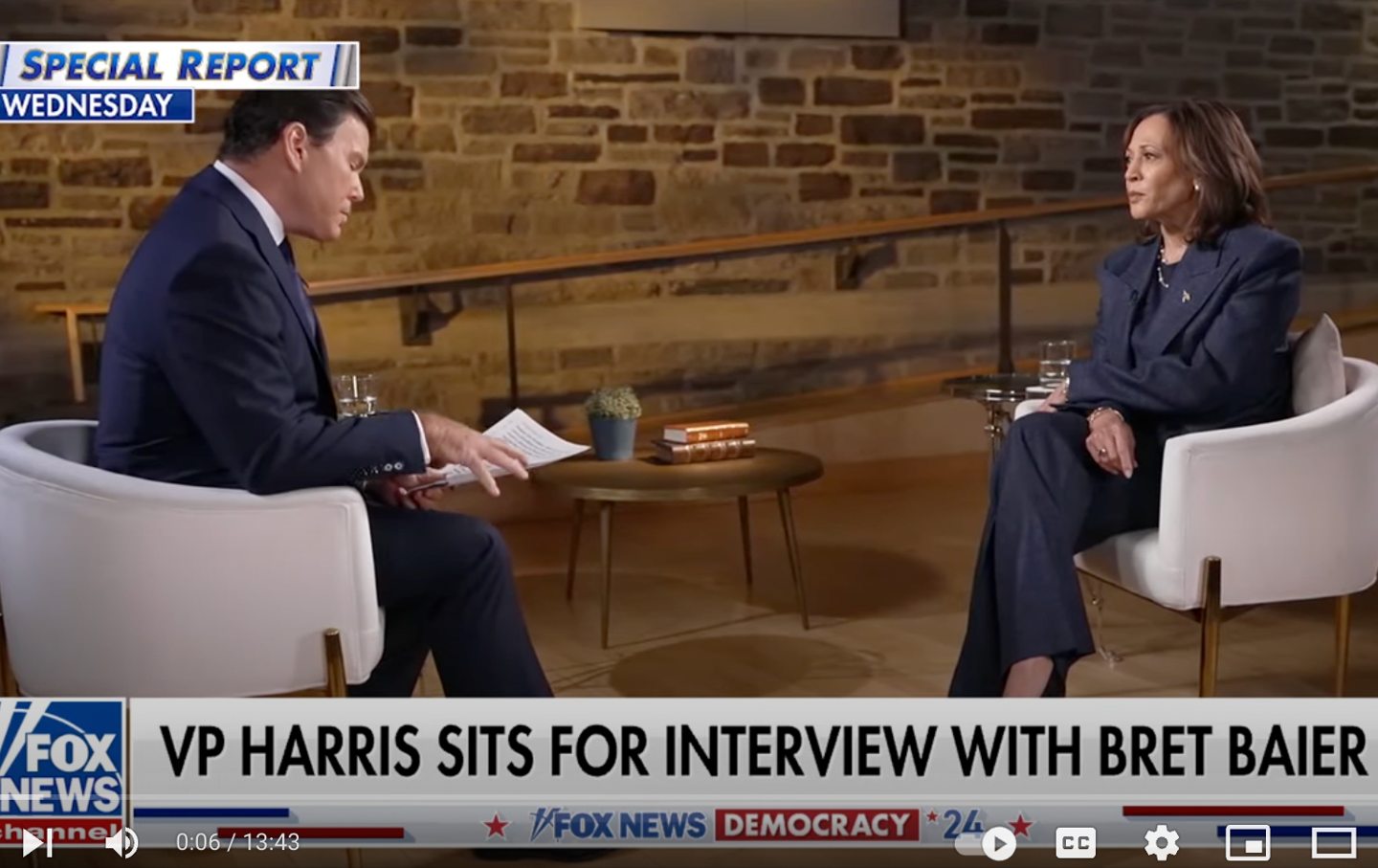 Bret Baier and Vice President Kamala Harris face each other, seated, during an interview, in front of a stone wall.