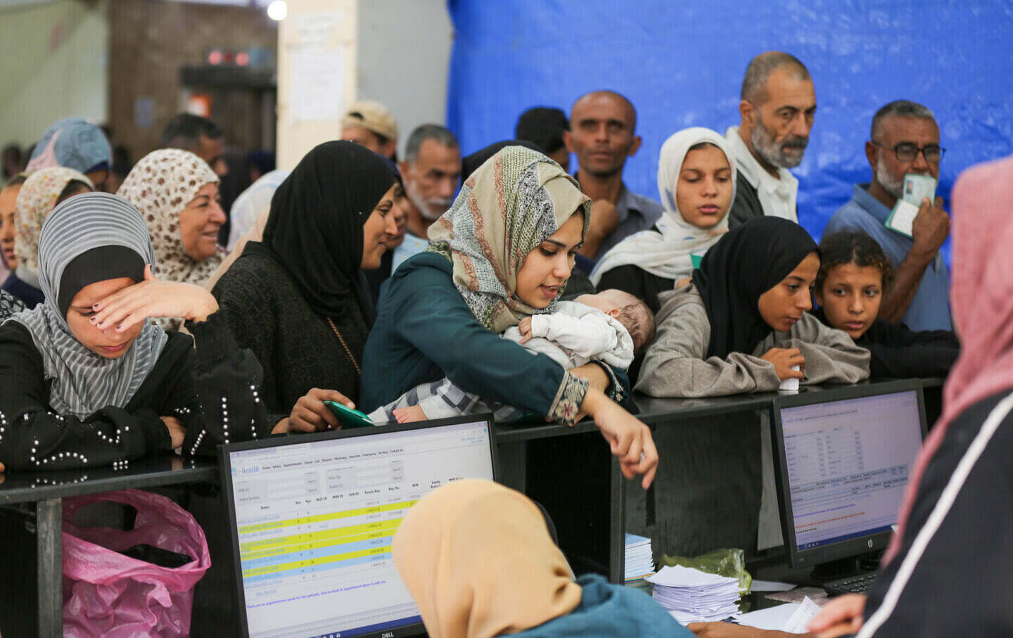 Palestinians wait in line at a United Nations Relief and Works Agency clinic in Deir al-Balah to receive medication and medical treatment as Israel's attacks on Gaza continue, creating harsh living conditions for the residents, on October 29, 2024.