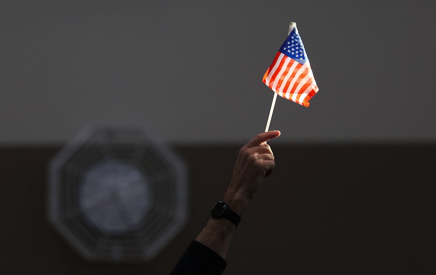 An election worker raises a flag while assisting voters at a polling station Las Vegas, Nevada, on Election Day, November 5, 2024.