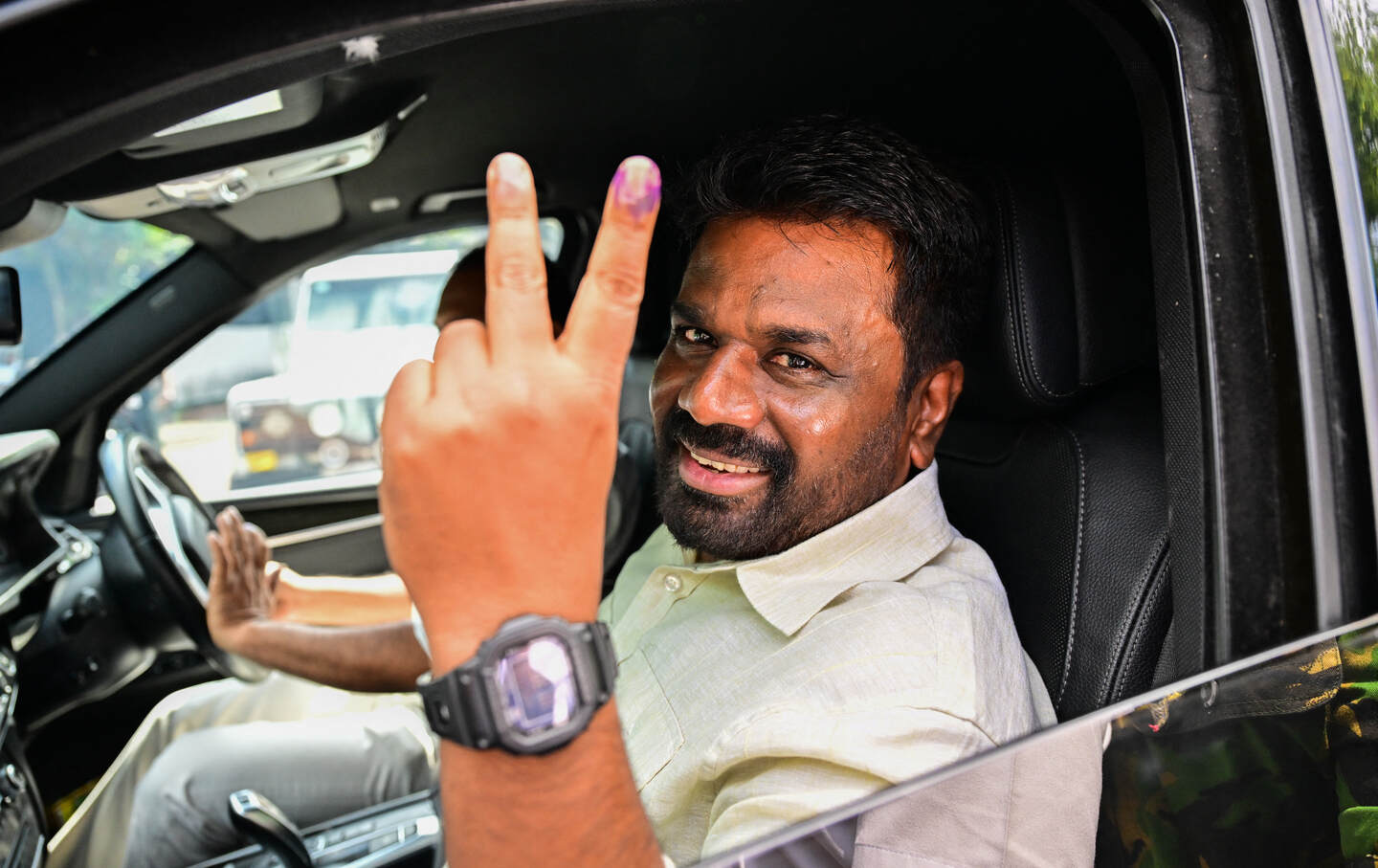 Sri Lankan President Anura Kumara Dissanayake shows his inked finger as he leaves a polling station after casting his ballot to vote in Sri Lanka's parliamentary election in Colombo on November 14, 2024.