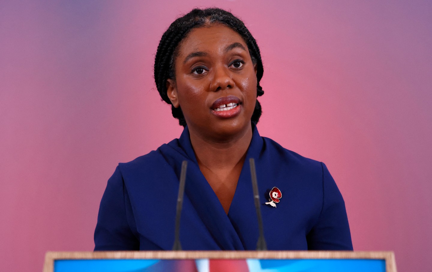 Kemi Badenoch in front of a podium.