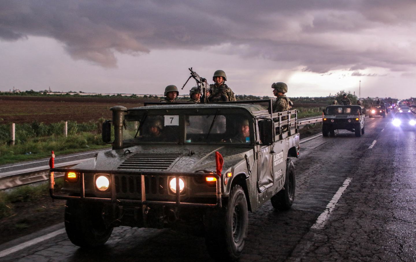 Mexican army soldiers aboard military vehicles patrol a highway as part of a military operation to reinforce security following a wave of violence in the city of Culiacan, Sinaloa State, Mexico, on August 19, 2024.