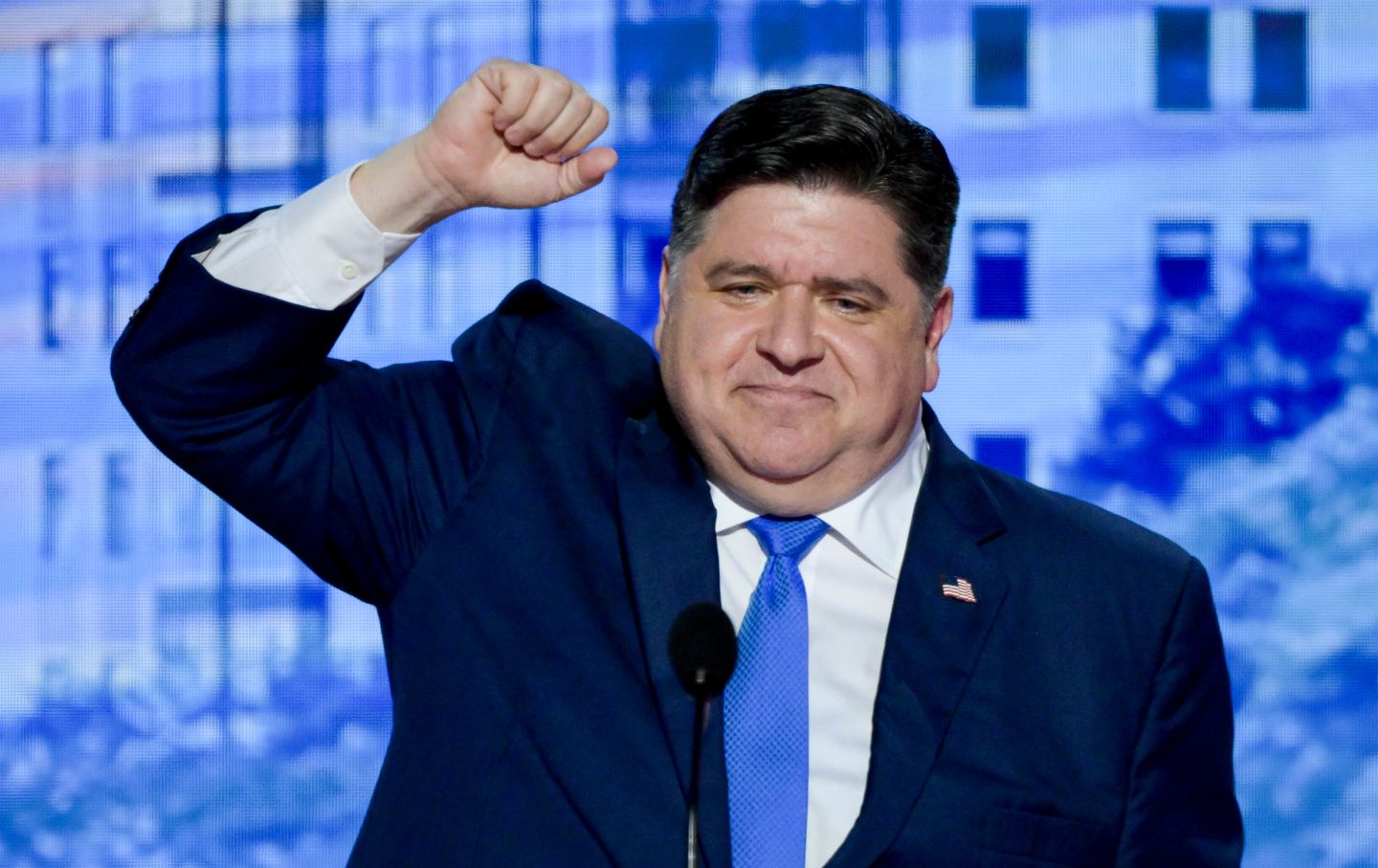 Close-up of Gov. Pritzker with his left hand up in a fist.