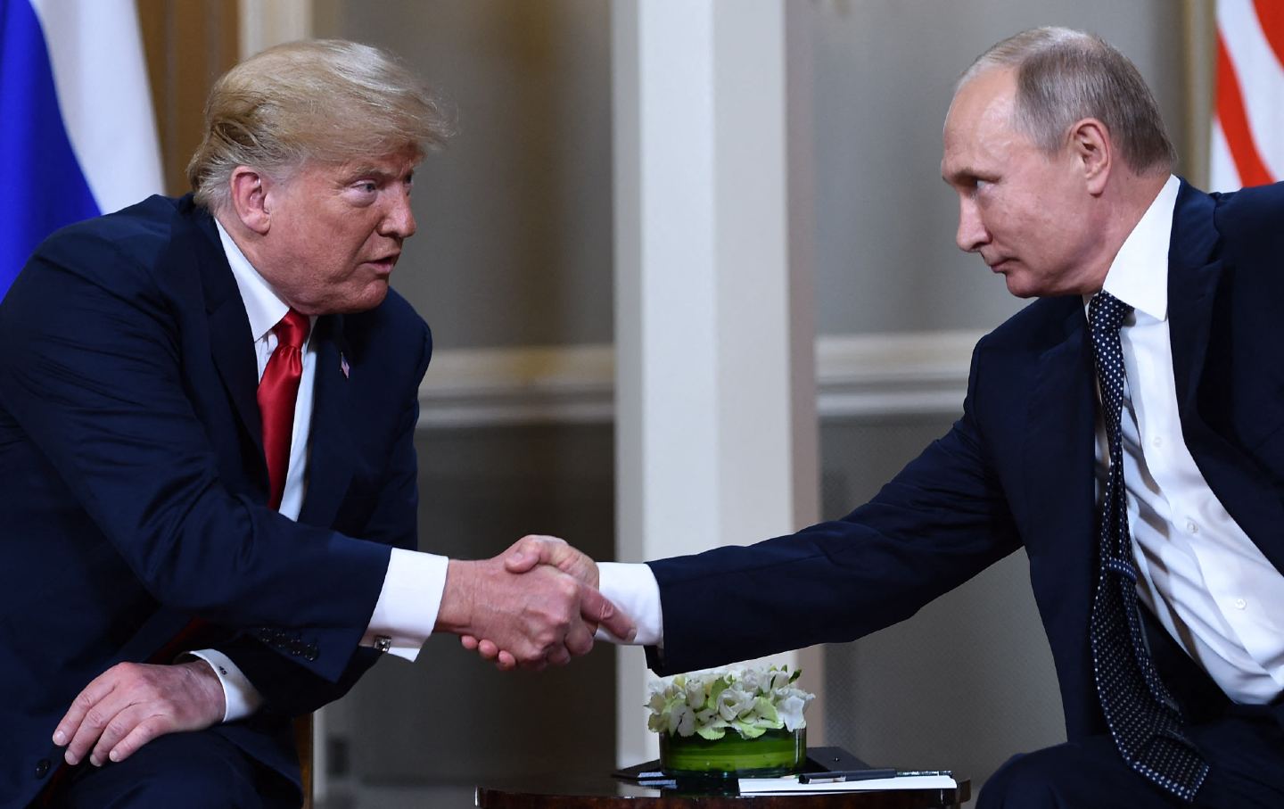 Russian President Vladimir Putin (R) and US President Donald Trump shake hands before a meeting in Helsinki, on July 16, 2018.