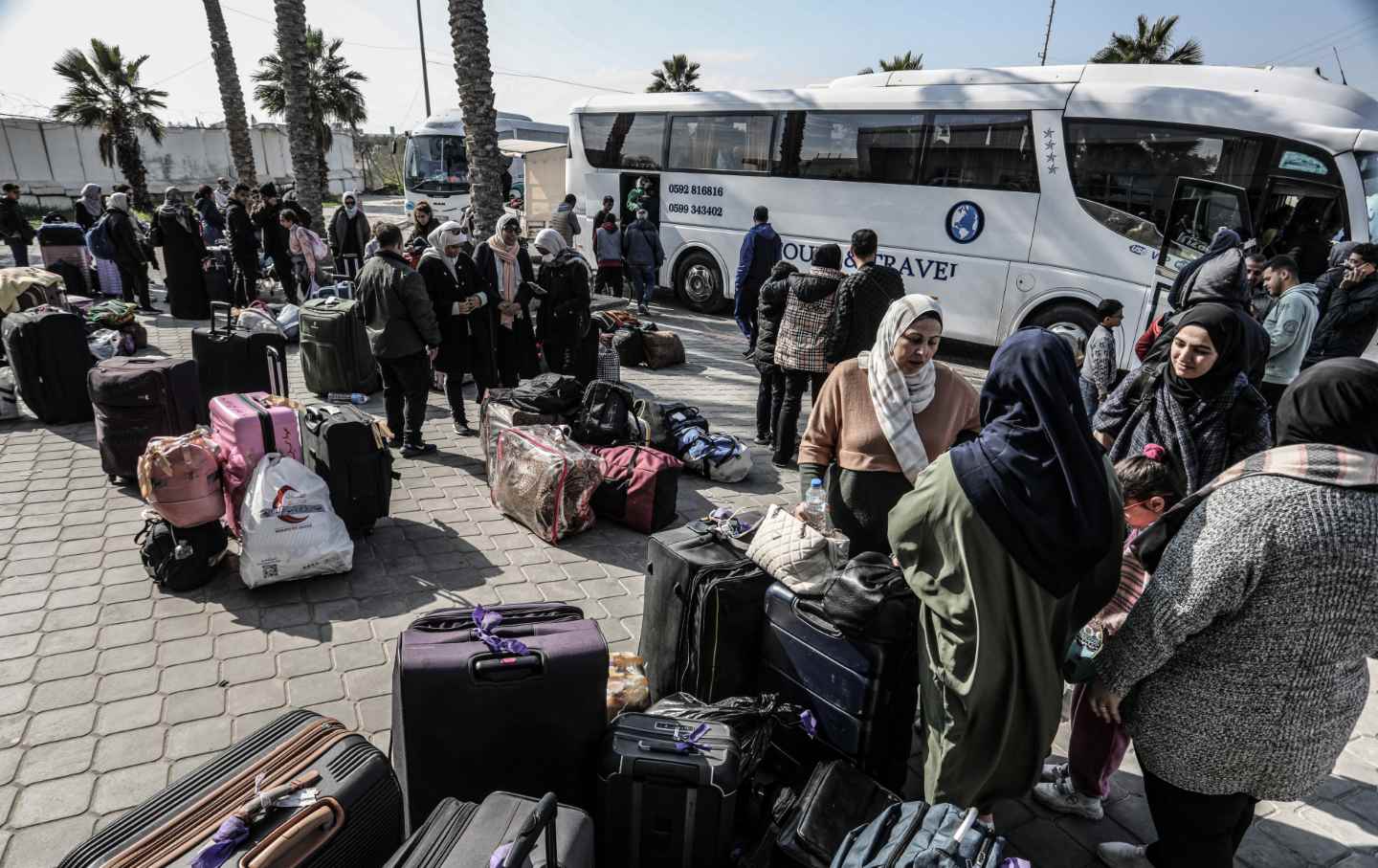 Palestinians, holding foreign passports, collect their luggage as they prepare to cross to Egypt from the Gaza Strip through the Rafah border crossing.