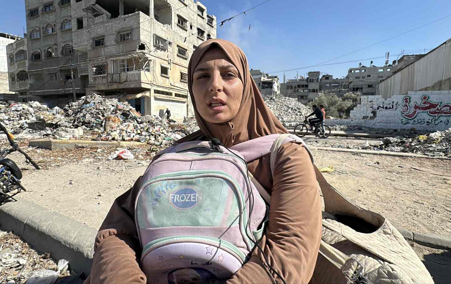 A Palestinian woman, carrying a backpack, arrives at Salah al-Din Road as the Israeli army forces Palestinian to leave Gaza City on October 22, 2024.