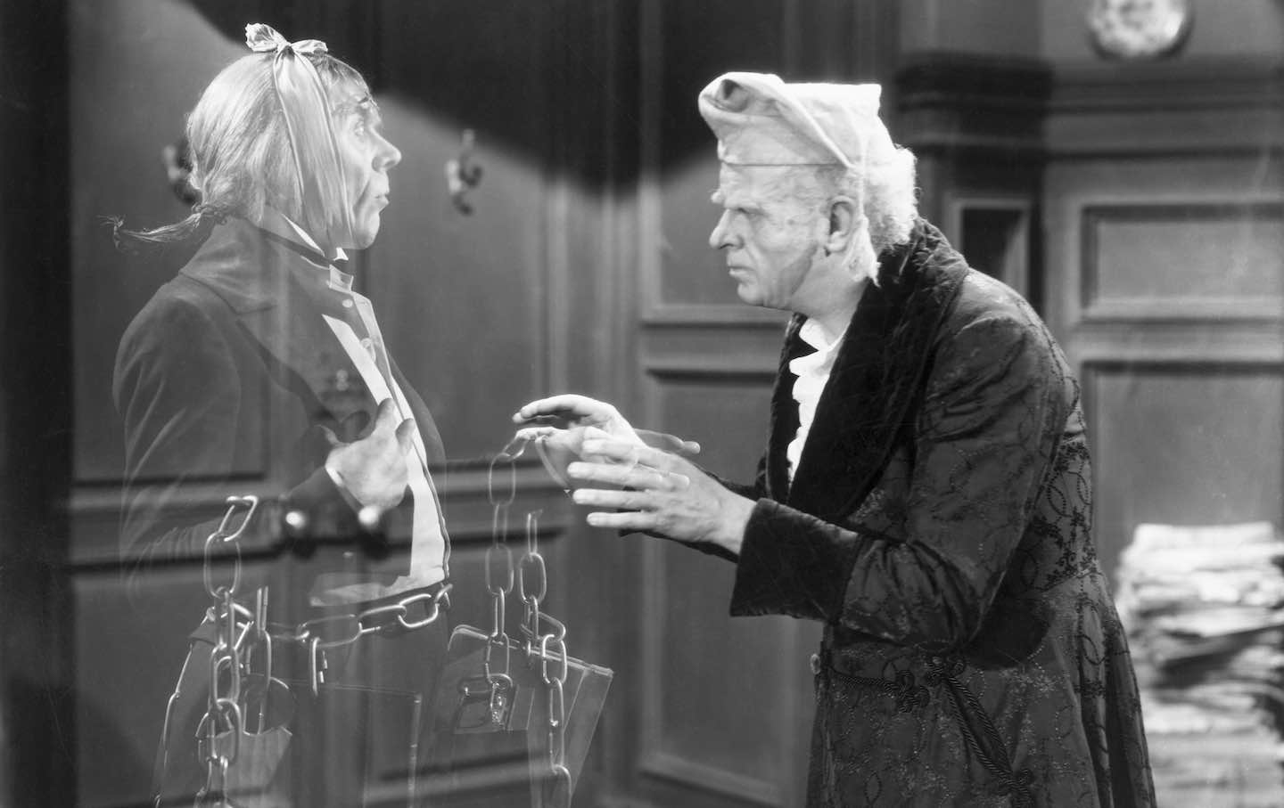 Reginald Owen, playing Scrooge, speaks with his dead business partner Marley, played by Leo G. Carroll, during the 1938 MGM production of “A Christmas Carol.”