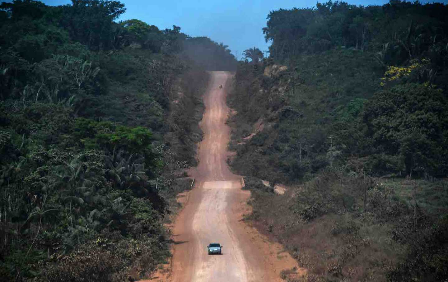 A car drives along a section under construction of the Trans-Amazonian highway near the Ruropolis, Para state of Brazil, in the Amazon rainforest, 2019. 