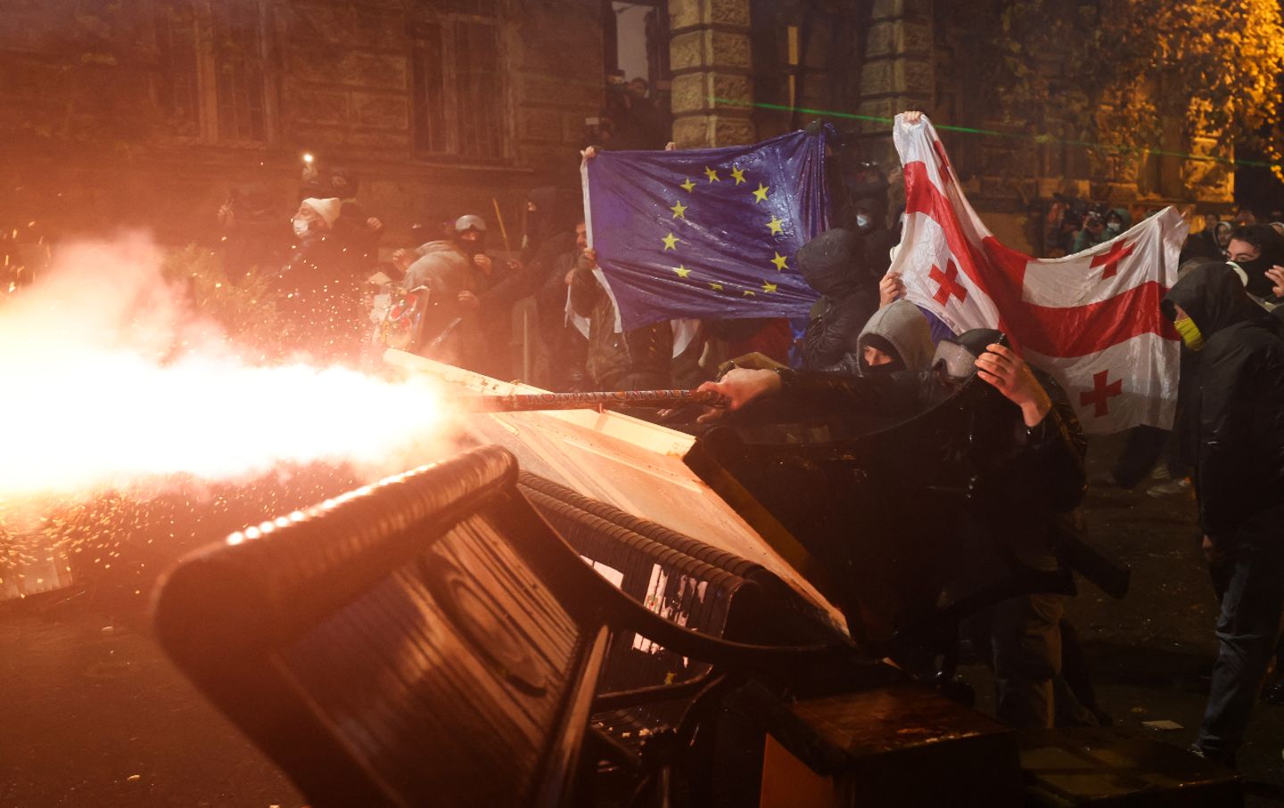 Protesters holding Georgian and European flags clash with police during a demonstration against the government's decision to delay European Union membership talks amid a postelection crisis, in Tbilisi, early on December 1, 2024.