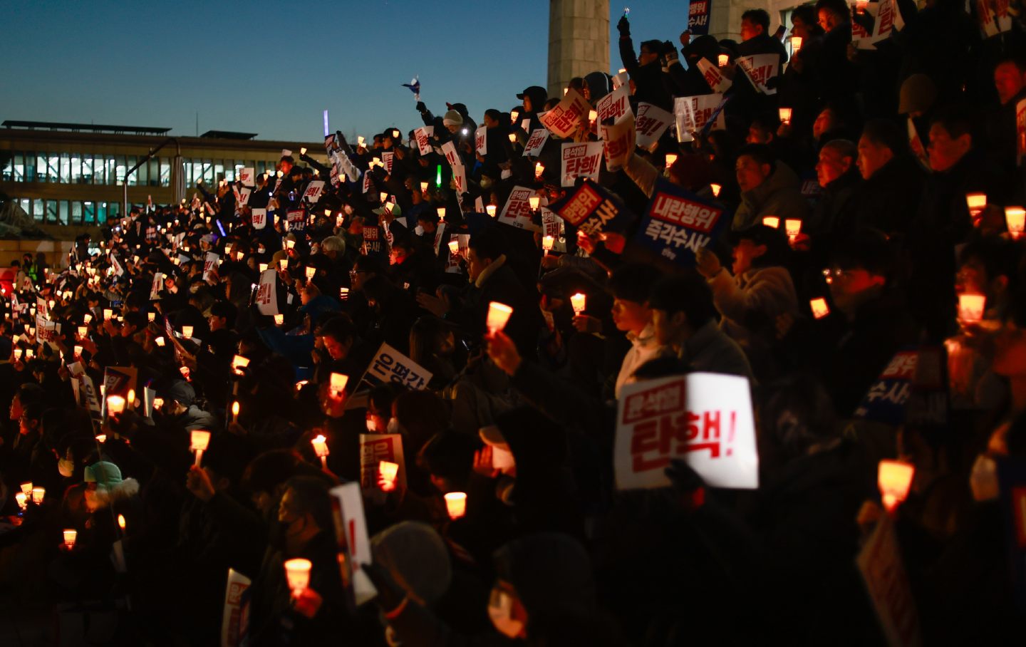 People protesting South Korean President Yoon Suk Yeol chant slogans as they attend a candlelight rally outside the National Assembly Building, in Seoul, South Korea, on December 4, 2024. Yoon Suk Yeol declared martial law in the late hours of December 3.