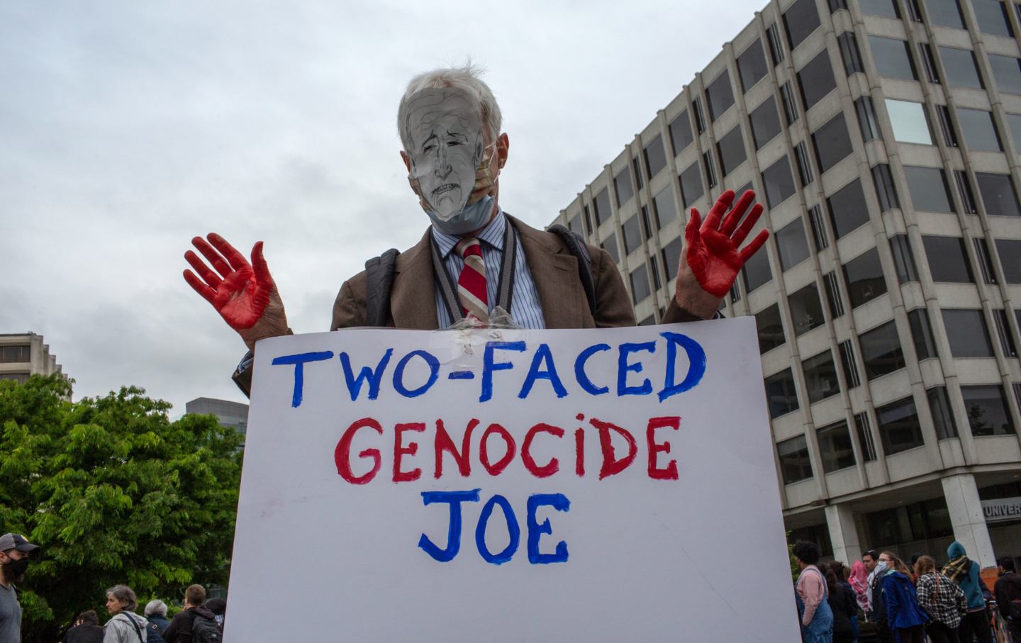 A Pro-Palestinian demonstrator wearing a face mask of President Joe Biden and holding a sign with “Two-Faced Genocide Joe” written on it as he joins in a demonstration in front of the Washington Hilton. Pro-Palestinian protestors demonstrate outside the White House Correspondents' Association dinner at the Washington Hilton .