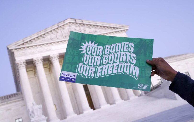 A DC community organizer holds a sign for the Light Brigade for Reproductive Justice: Your Vote is Your Voice outside of the US Supreme Court on October 17, 2024.