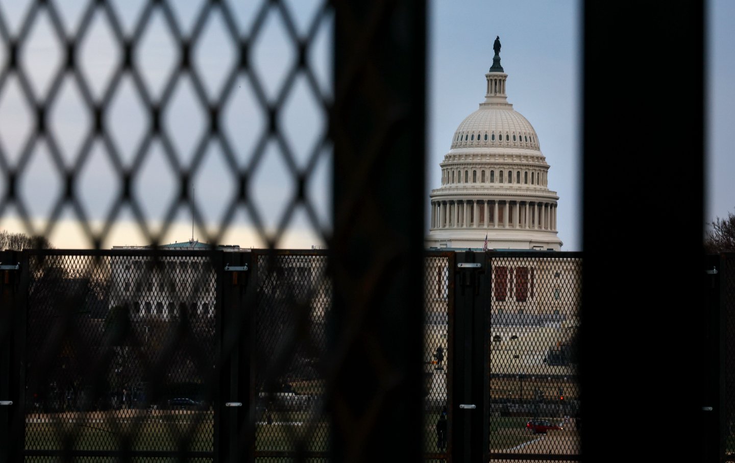 A view of the US Capitol through security fencing.