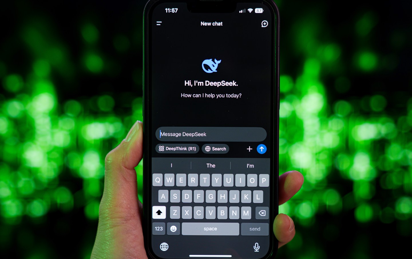 A hand holds an iPhone. The screen shows the application DeekSeek asking, 