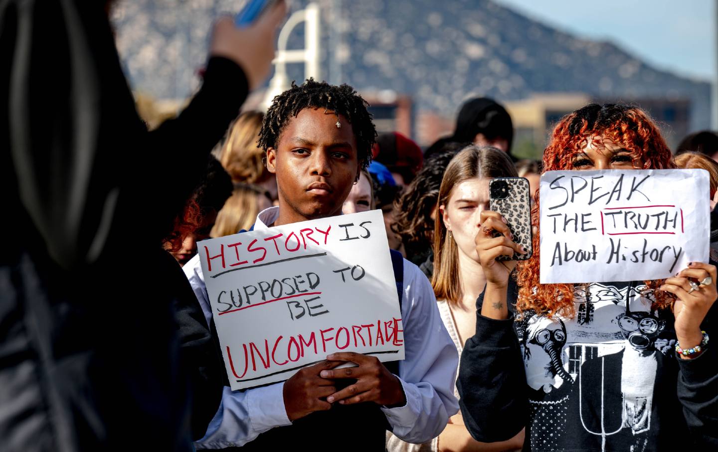 Great Oak High School students hold signs during a protest of the district’s ban of critical race theory curriculum at Patricia H. Birdsall Sports Park in Temecula, California., on December 16, 2022.