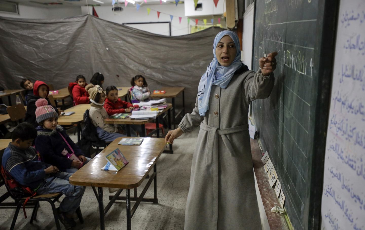 Palestinian children attend a lesson in a classroom at a damaged school amid a ceasefire between Israel and Hamas in Gaza City, on February 26, 2025.