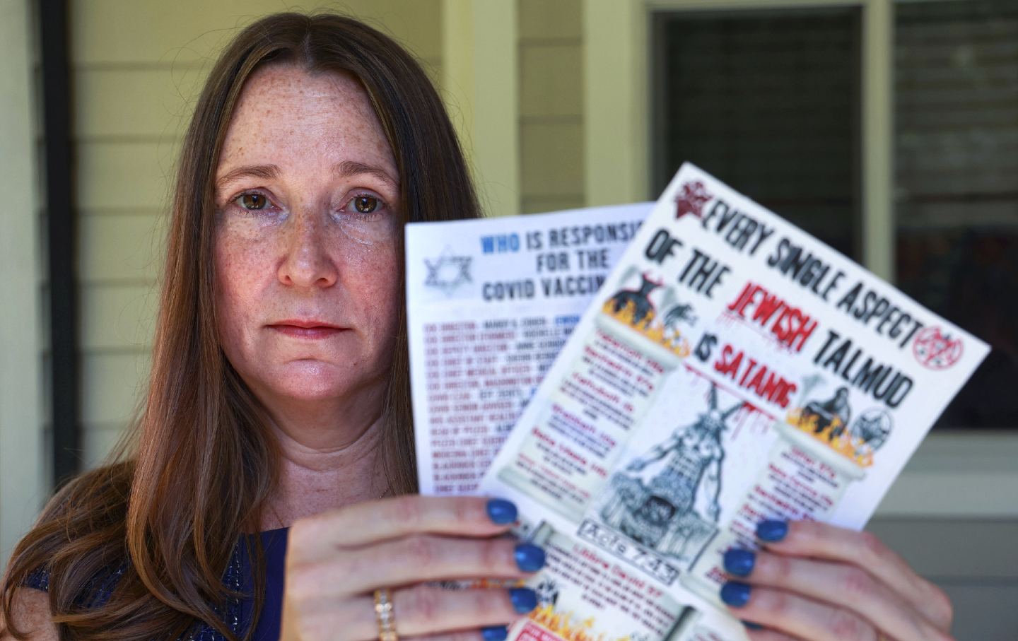 Florida resident Ann Richter holds antisemitic flyers she found on her lawn.