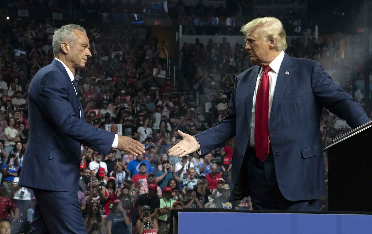 Robert F. Kennedy Jr. and President Donald Trump shake hands during a campaign rally at Desert Diamond Arena on August 23, 2024. in Glendale, Arizona.