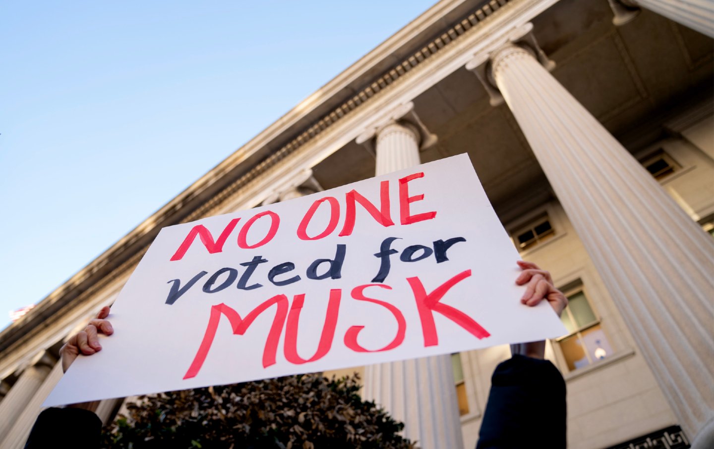 A demonstrator holds a sign during a protest against Elon Musk outside the US Treasury building in Washington, DC, on, February 4, 2025.