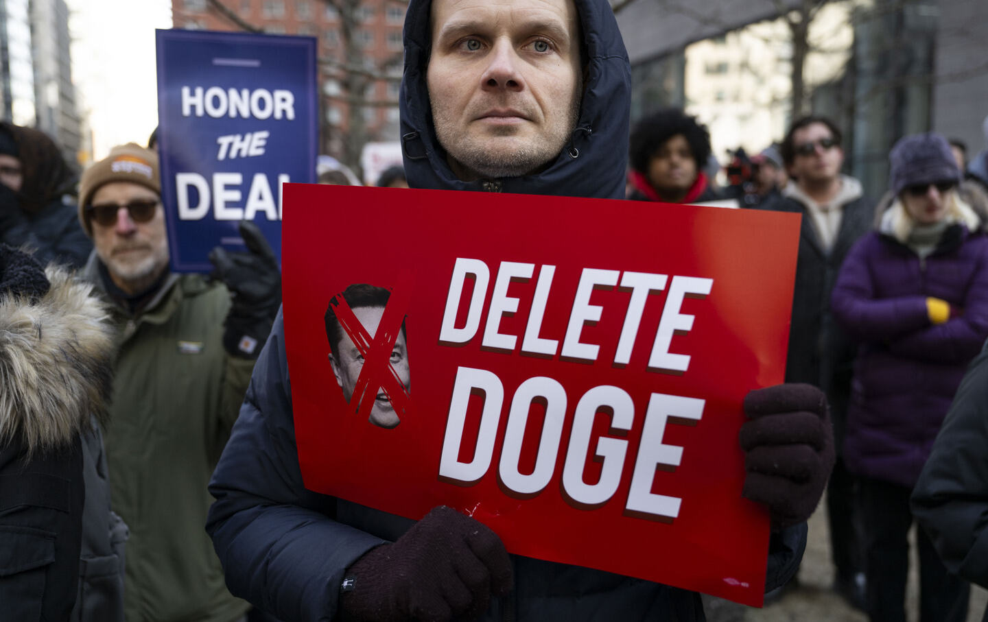 A protester holds a sign during a rally against Donald Trump and Elon Musk's Department of Government Efficiency (DOGE) in New York City on February 19, 2025.