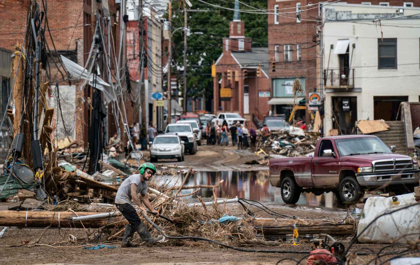 Workers, community members, and business owners clean up debris in the aftermath of Hurricane Helene in Marshall, North Carolina, on September 30, 2024.