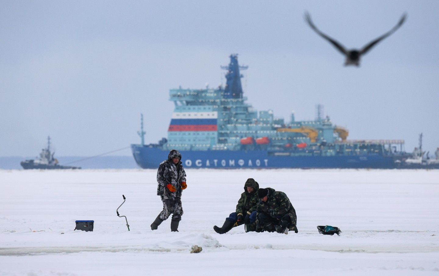 Fishermen work on the ice of the Gulf of Finland against the backdrop of the nuclear icebreaker Yakutia, a key tool in Russia's Arctic program, while US President Donald Trump has ordered the development and approval of a program to acquire a US icebreaker fleet.