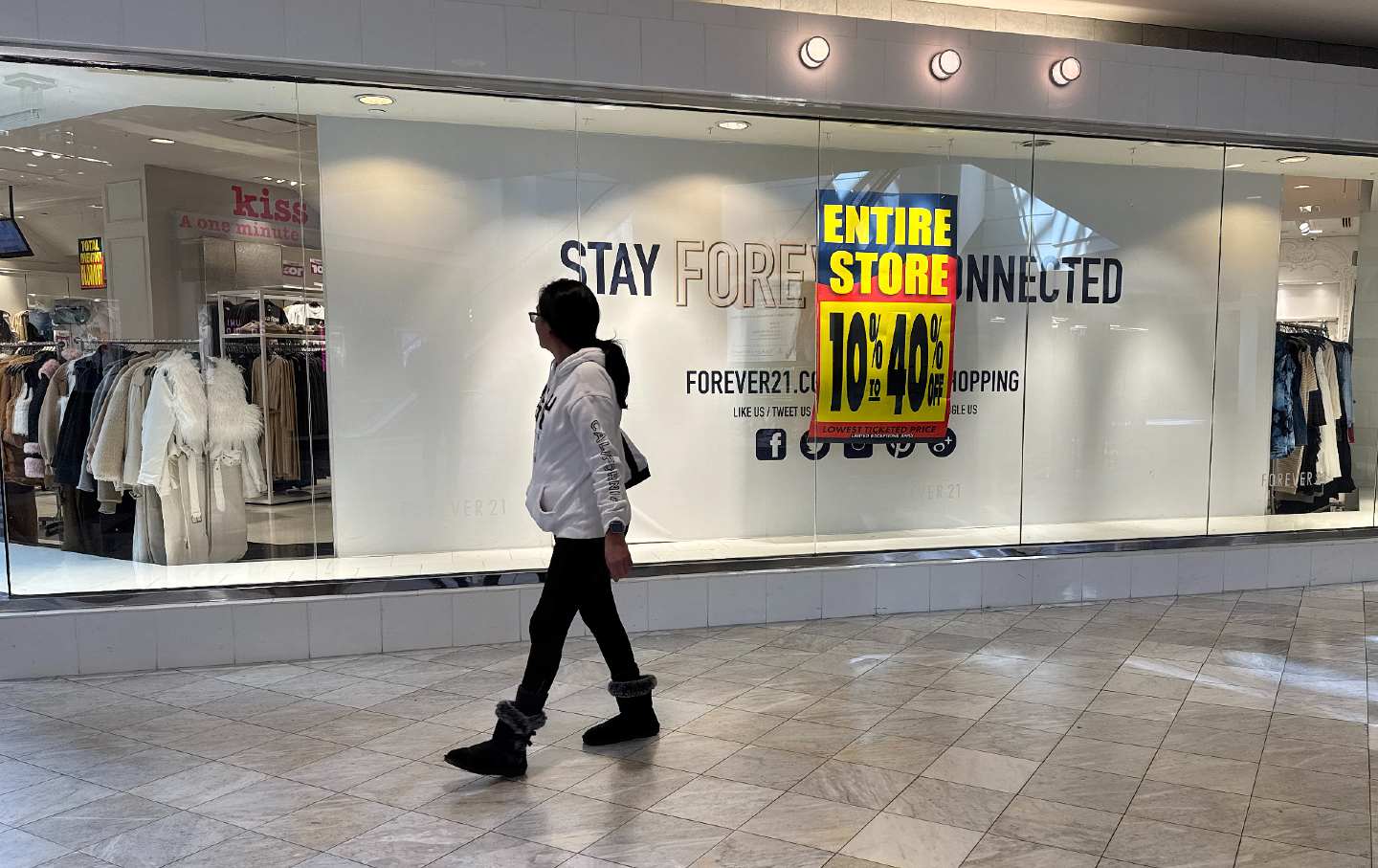 Person walking by a store. A sign readers 