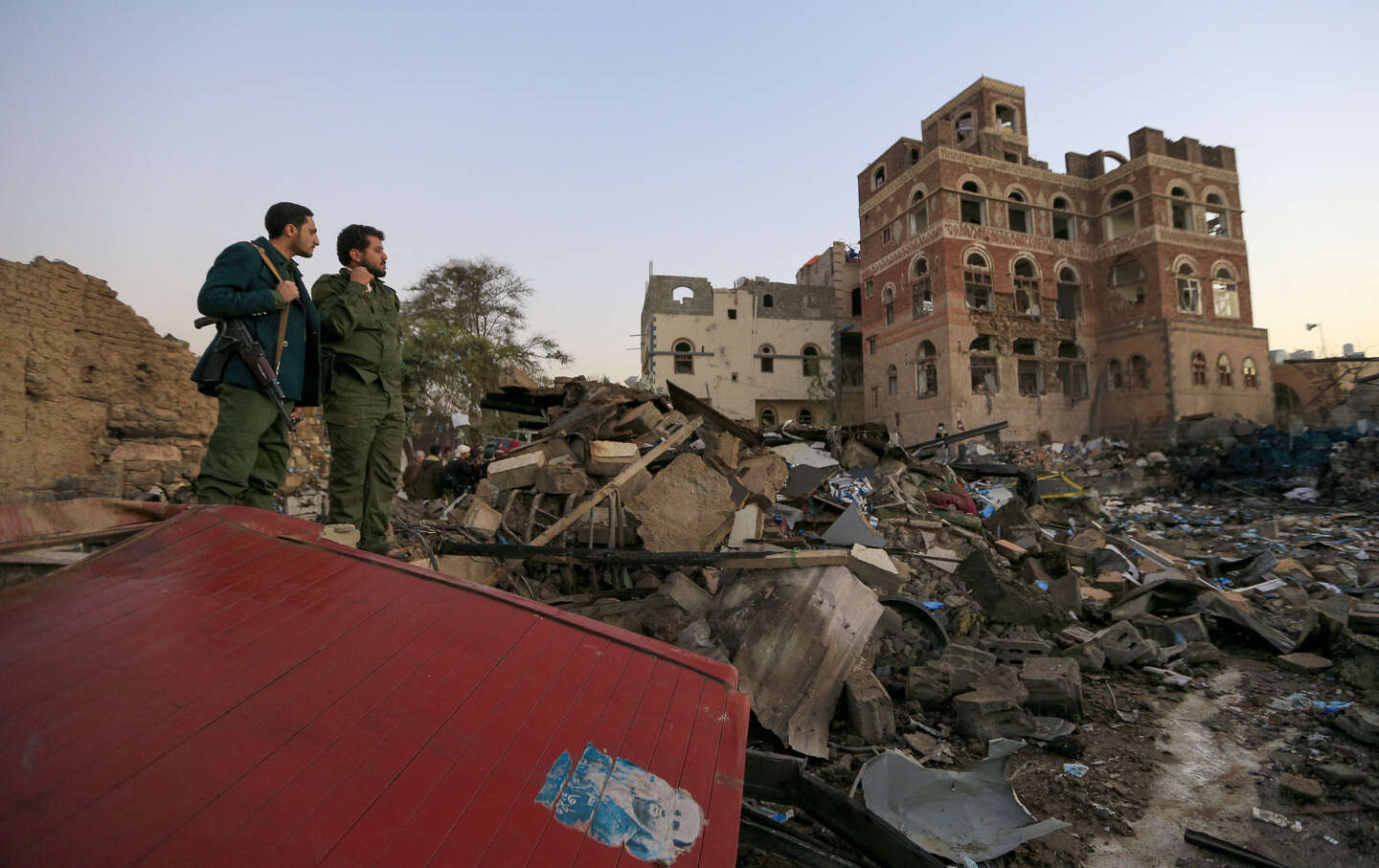 Huthi fighters check the damage in an area struck by a US air strike in Sanaa on March 20, 2025.