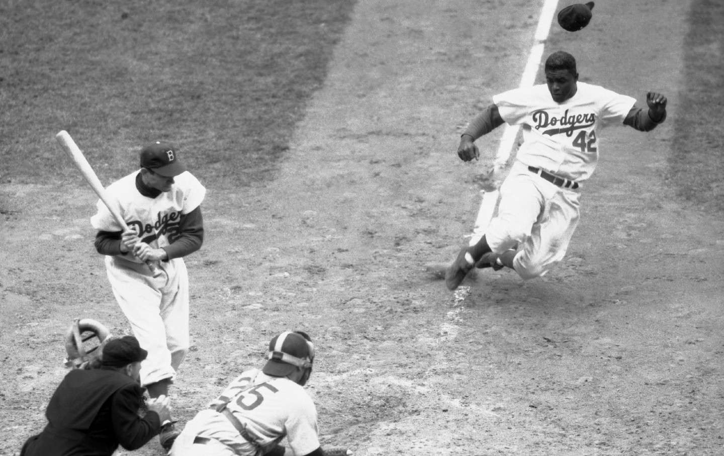 Dodger Jackie Robinson stealing home in a Cubs game on May 1, 1952.