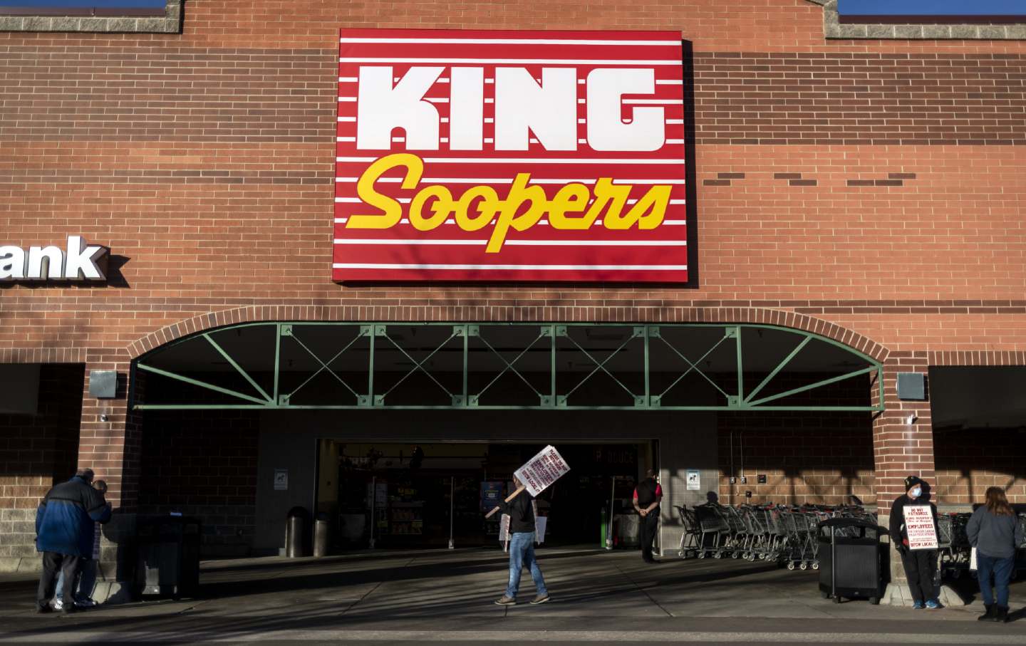 Union workers hold signs during a strike outside a King Soopers grocery store location in Westminster, Colorado, on January 12, 2022.