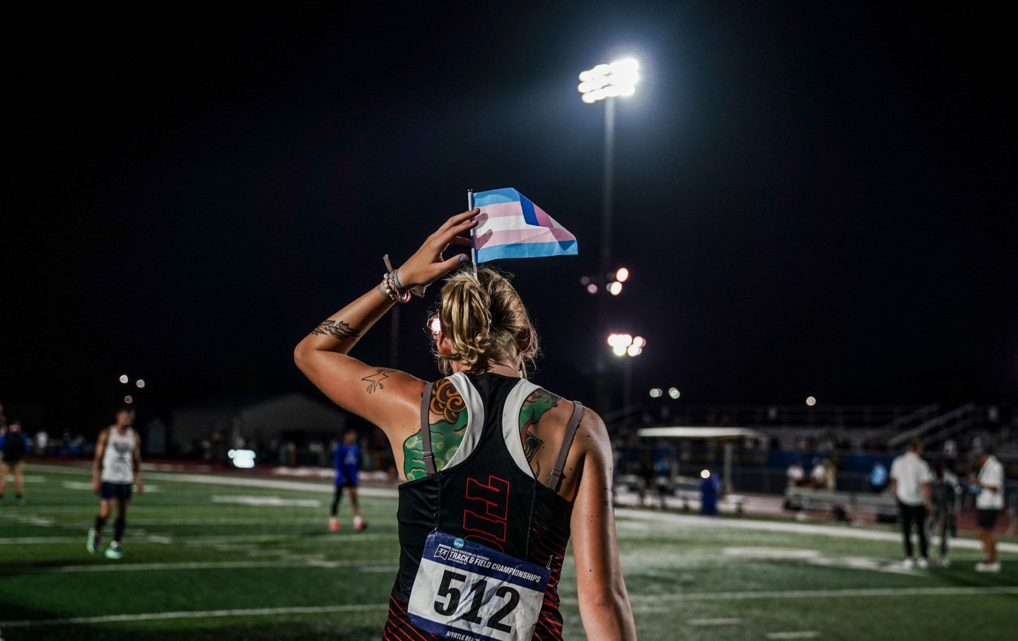 Sadie Schreiner puts a transgender flag in her hair before heading to the awards stand after finishing third in the finals of the 200m race at the 2024 NCAA DIII outdoor track and field championships at Doug Shaw Memorial Stadium on May 25, 2024, in Myrtle Beach, South Carolina.