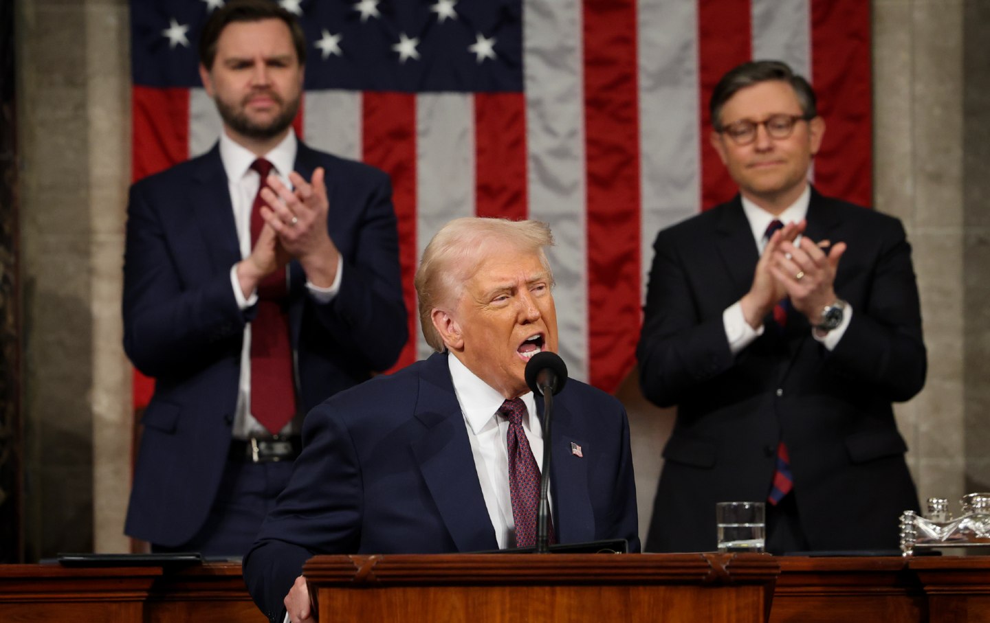 Presiden Donald Trump membahas sesi gabungan Kongres di Capitol AS pada 4 Maret 2025, di Washington, DC. Wakil Presiden JD Vance dan Ketua DPR Mike Johnson bertepuk tangan di belakangnya.